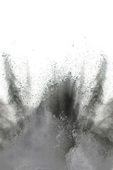Black powder explosion on white background. Black dust particles splash.