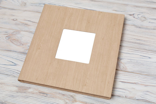 photo book with  leather cover.
Wedding photo album.
Beige photobook on a wooden background.
photo album with insert

