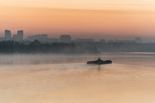 Barge sailing Dneper river before sunrise early in the morning in Kyiv, Ukraine.
