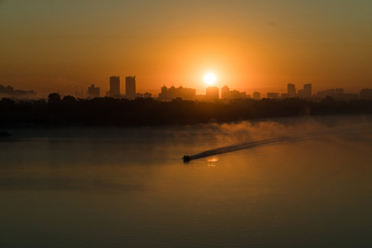 Boat sailing Dneper river before sunrise early in the morning in Kyiv, Ukraine.