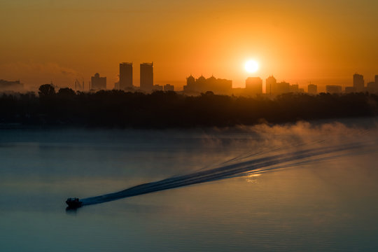 Boat sailing Dneper river before sunrise early in the morning in Kyiv, Ukraine.