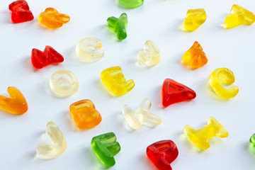 Shiny gummy letters from latin alphabet on a white background