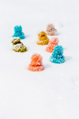 Group of colorful knitted hats in the snow. Funny concept of friendship and togetherness at winter holidays.