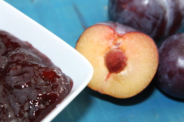 Plums and plummy jam on blue background.