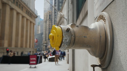 Fire hydrant in the wall of a building on Wall Street in New York