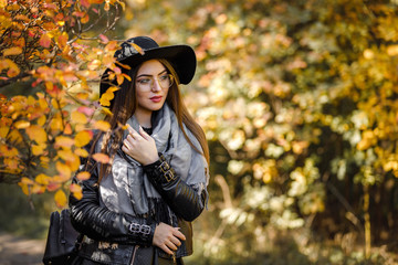 Fototapeta na wymiar beautiful woman in black dress and hat in autumn