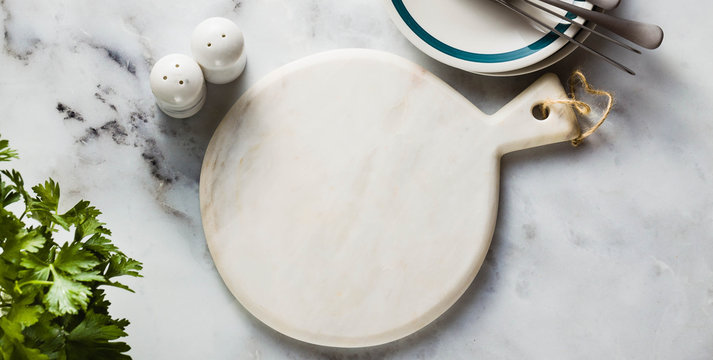 Banner Of Empty Marble Cutting Board On A Marble Table. Copy Space