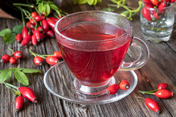 A cup of rose hip tea with fresh rose hips