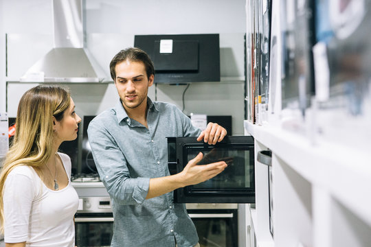 Young man and woman looking at the features of an appliance