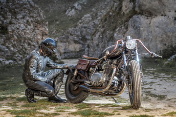 Biker with black leather suit and mask stay on a custom special rat motorbike.
Post apocalyptic...