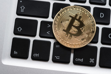 Cryptocurrency Bitcoin coin on computer laptop keyboard. Finance, investment and money concept
