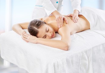 Fototapeta na wymiar Beautiful young woman enjoying head massage in spa center