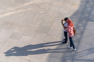 Aerial photo of people walk on the walkway in front of the mall in the city