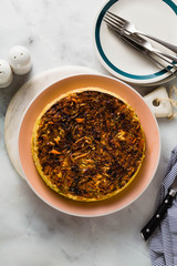 savory salty  Upside-Down pie from white cabbage, carrots and onions. gluten free no eggs , with chickpea flour. family breakfast or party snack on a white marble table
