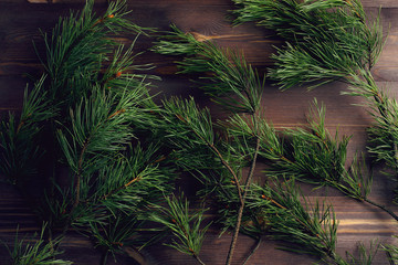 Pine branches on a wooden dark background. Christmas tree. Flat lay, top view