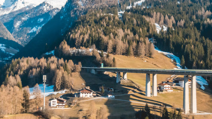 Beautiful bridge at the Brenner with snowy mountains and orange teal look