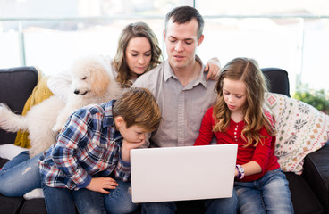 Parents with children enjoying movie on laptop together