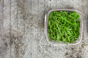 Arugula - fresh salad (rucola) on a gray background. top view. copy space