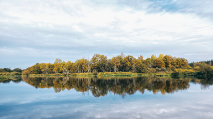 Scenic autumn river with trees on the shore.