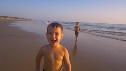 4K Slow motion - Two little brothers running, playing and enjoying while the camera chase them smiling and laughing