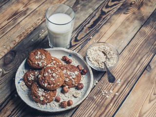 Oatmeal cookies and milk on a wooden background