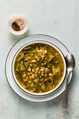 gluten free green minestrone with cannellini beans. on the table with spices and arugula pesto. Traditional Italian Tuscan soup. healthy food for the whole family on the blue table