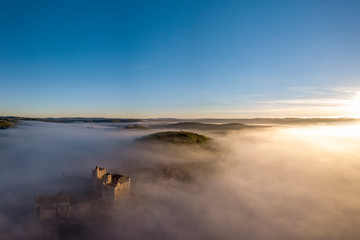 Chateau Beynac in fog in the early morning Perigord Noir Dordogne France