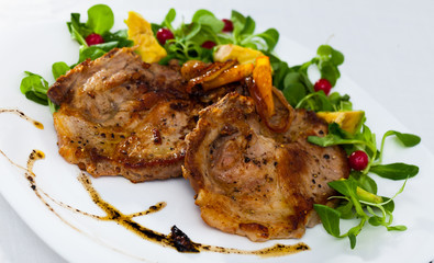 Tasty cooked fried pork chops with  avocado, greens  and berries