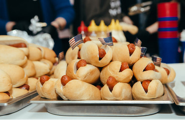 many hot dogs on table with small american flags barbecue picnic party