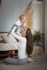 Mother lifted son in the air above head,real room