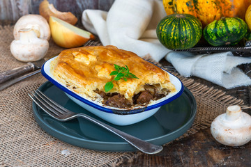 Steak and mushroom pie on rustic wooden backgournd