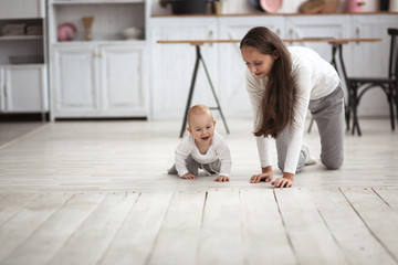 mother and baby crawling together on the floor
