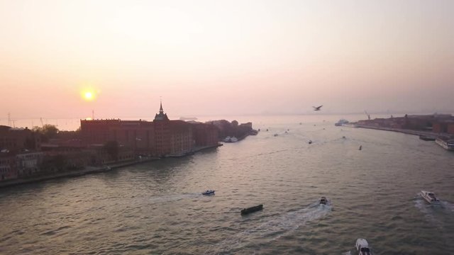 Panning aerial, sunset over river in Venice