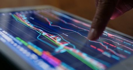 Stock market data on tablet computer at night