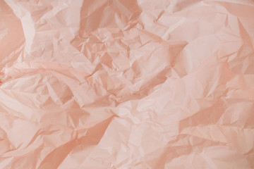 Fototapeta premium Pastel peachy crumpled paper texture.