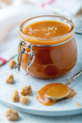 Salted caramel in a jar on a white plate.