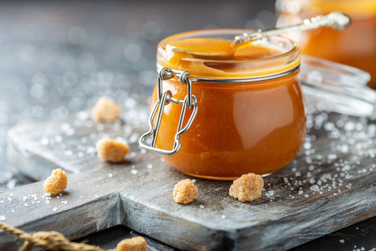 Salted caramel and a spoon in a glass jar.