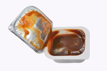 open plastic container with sauce ketchup or a barbecue isolated on a white background