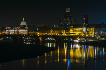 Fototapeta na wymiar View of the old town of Dresden at night with a view of water and the reflection of the city as well as, churches, towers and buildings. Elbe river. Germany. Saxony.