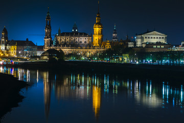 Fototapeta premium View of the old town of Dresden at night with a view of water and the reflection of the city as well as, churches, towers and buildings. Elbe river. Germany. Saxony.