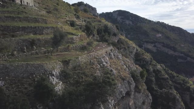 Panning aerial, rocky cliffs on Amalfi Coast