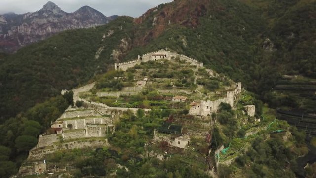 Italian castle in lush mountains, aerial
