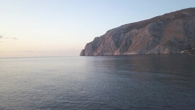Pan left aerial, coastal cliffs at sunset
