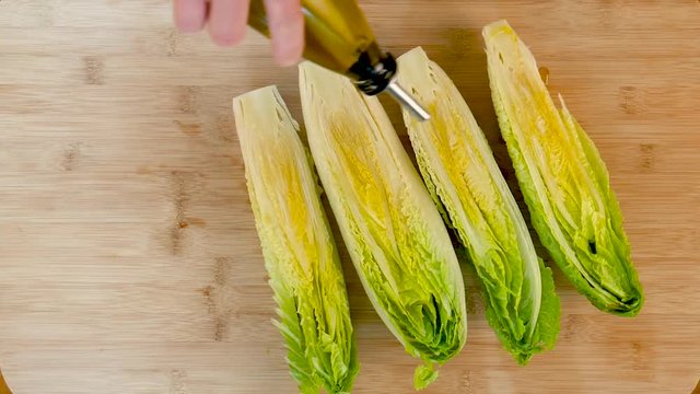 Drizzling olive oil over romaine lettuce, close up