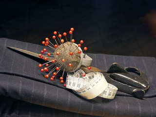 Pincushion, scissors and measuring tape in tailoring
