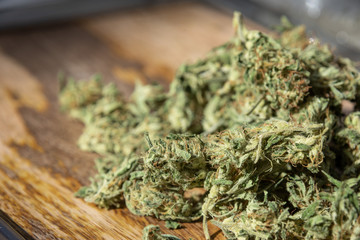 Fototapeta na wymiar Homegrown Marijuana Buds. Cannabis Flowers on Wood Table Background with Copy Space.