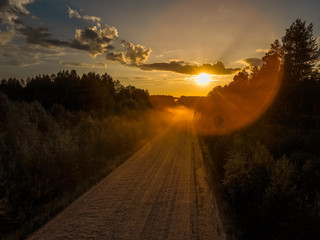 Gravel road in the Russian forest at sunset
