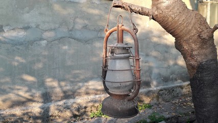 Hurricane lamp storm lantern. Very corroded vintage kerosene lamp. Classical oil lamps hanged on a...