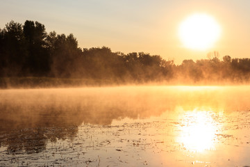 View of river in the mist at sunrise. Fog over river at morning