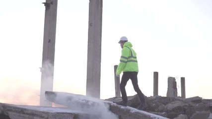 rescuer in a signal vest after an earthquake is looking for victims in a disaster
